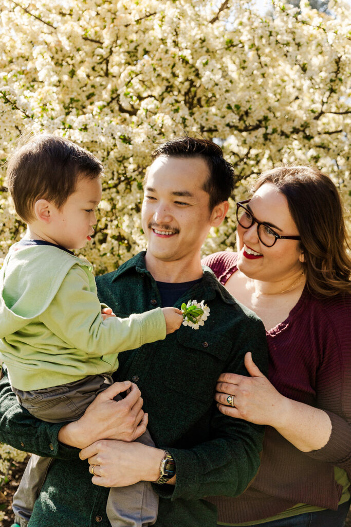 Beautiful spring flowers surrounding a family during a spring mini photo session at the Omaha OPPD Arboretum.