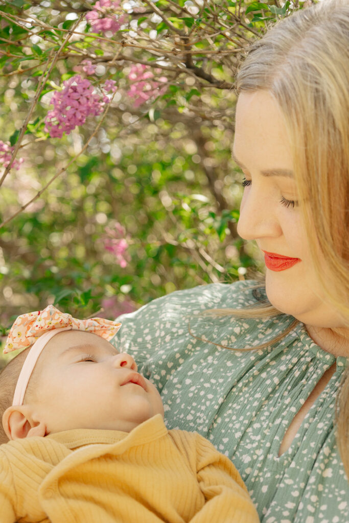 Spring family photos with parents, a newborn, and a toddler at Omaha's OPPD Arboretum surrounded by blooming flowers.