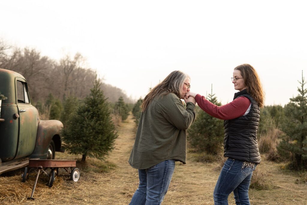 An engagement session at Nordstrom's Christmas Tree Farm near Omaha, NE featuring two women in a lesbian engagement session.